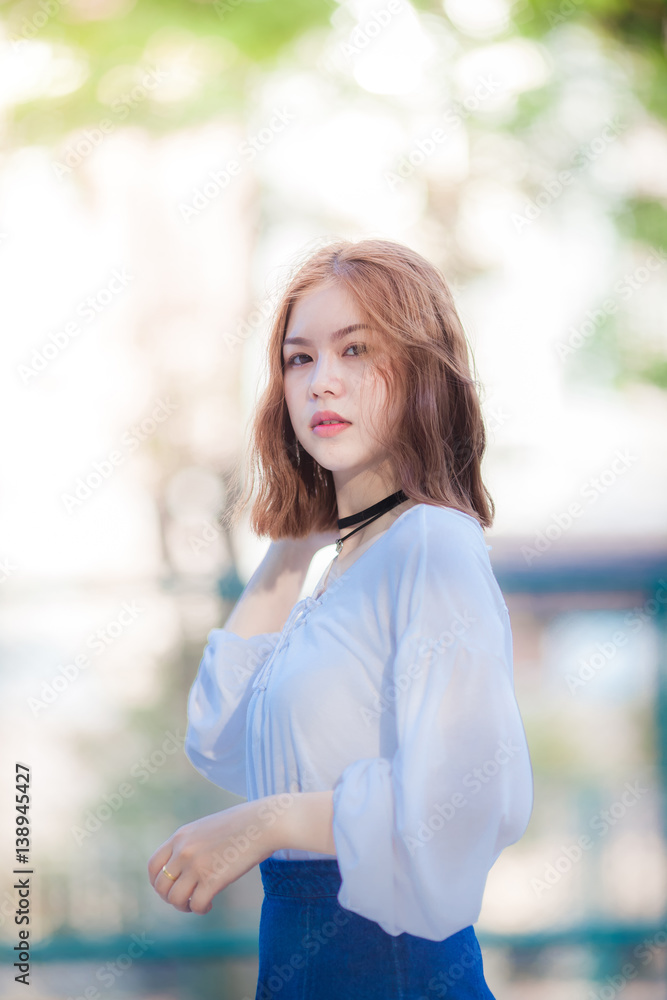 Portrait of young hipster Asian girl posing in the Tennis court background