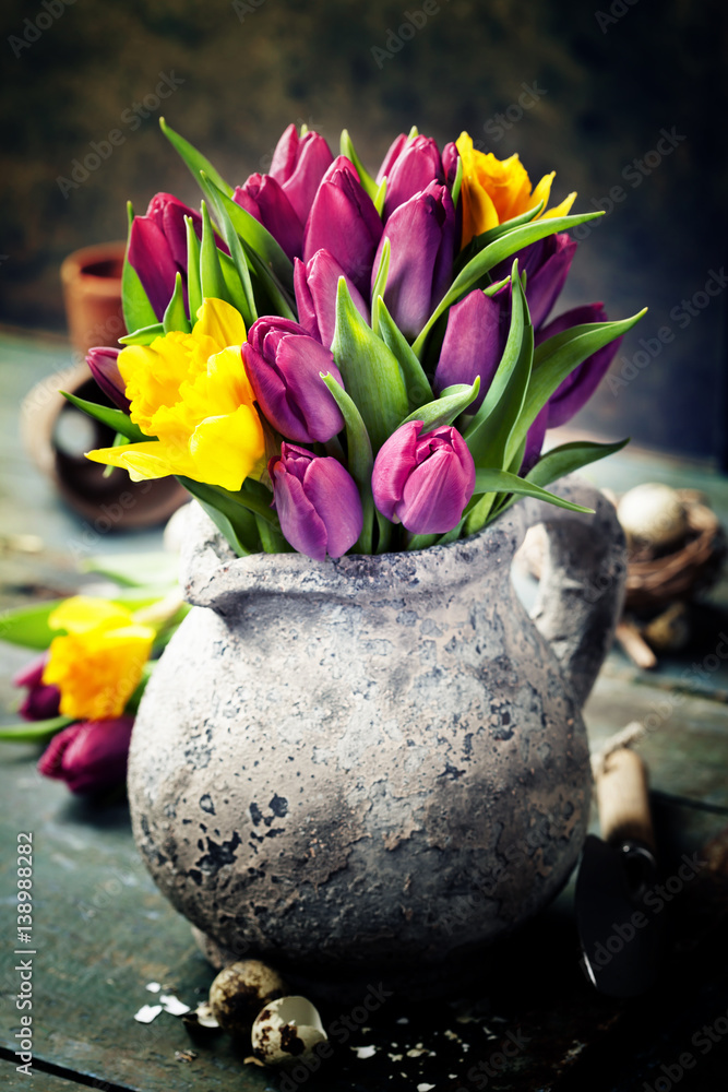 Beautiful spring tulips bouquet, easter eggs and garden tools