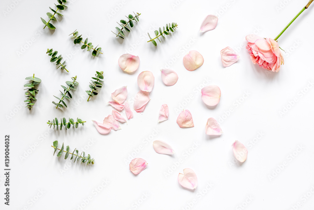 floral pattern with rose petals and eucalyptus on white table top view