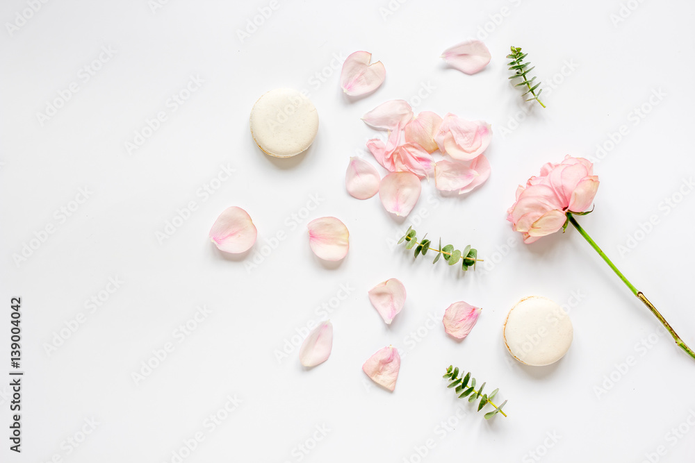 flat lay with petals and macaroons on white background top view