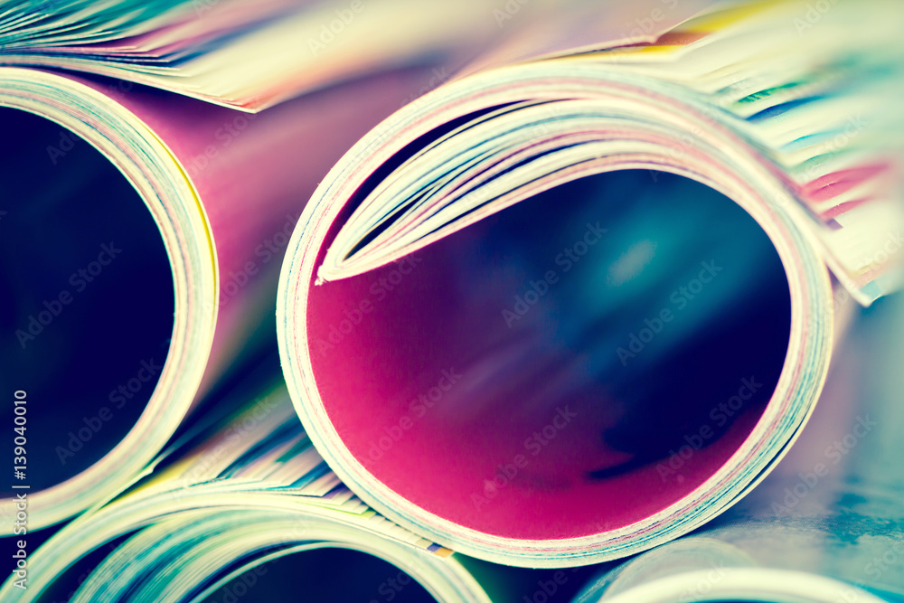 Close up edge of colorful magazine stacking roll with  blurry bookshelf background for bublication a