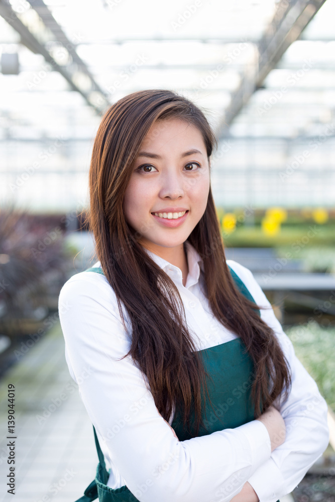 young asian woman works in green house