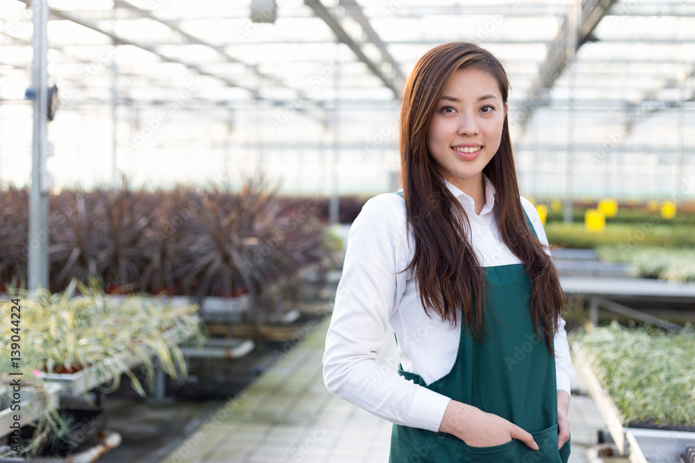 young asian woman works in green house