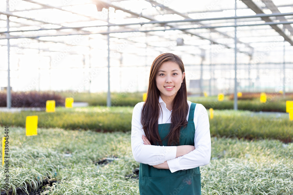 young asian woman works in green house