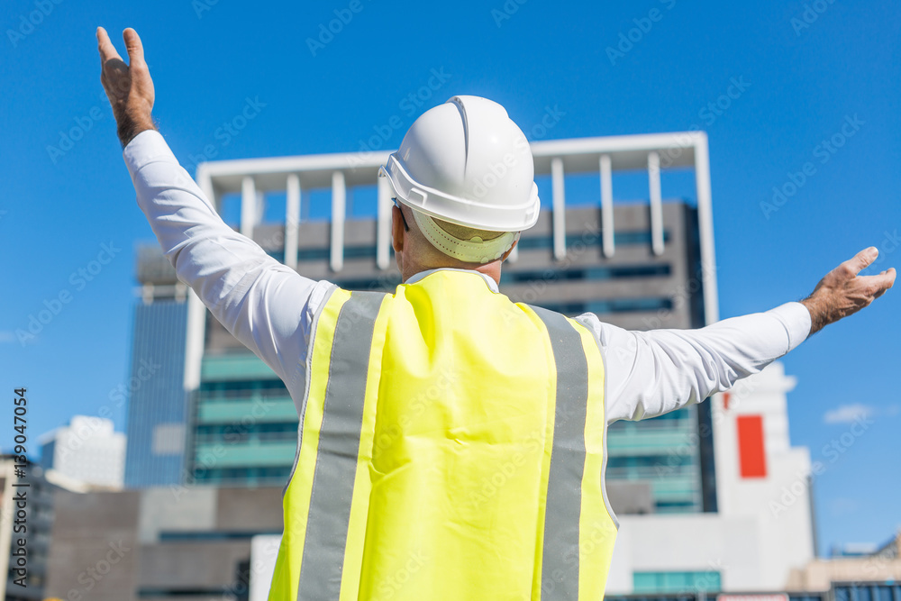 Senior foreman in glasses doing his job at building area on sunny day