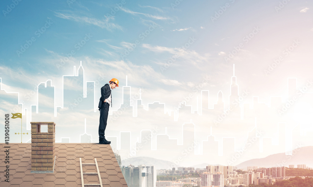 Engineer man standing on roof and looking down. Mixed media