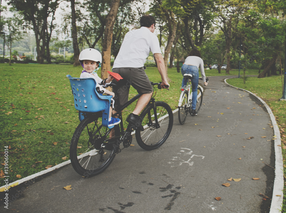 Family riding bicycle in the park on holiday