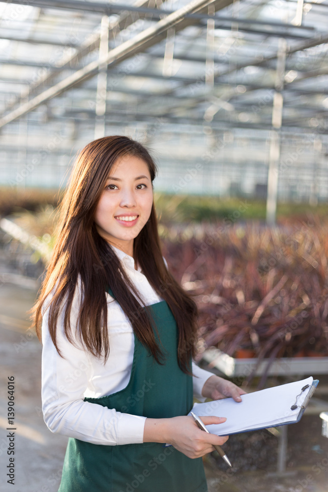 young asian woman works in green house