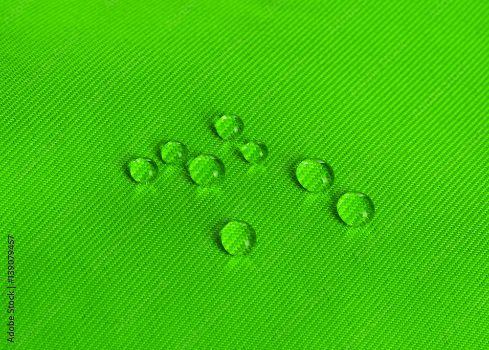 Green waterproof fabric with waterdrops close up