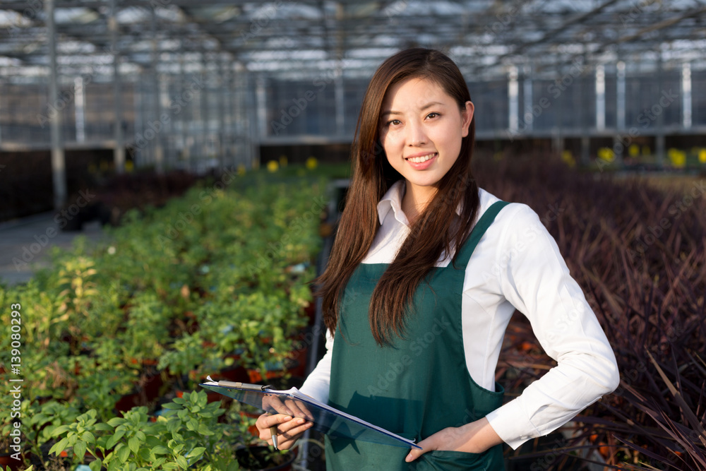 young asian woman works in green house