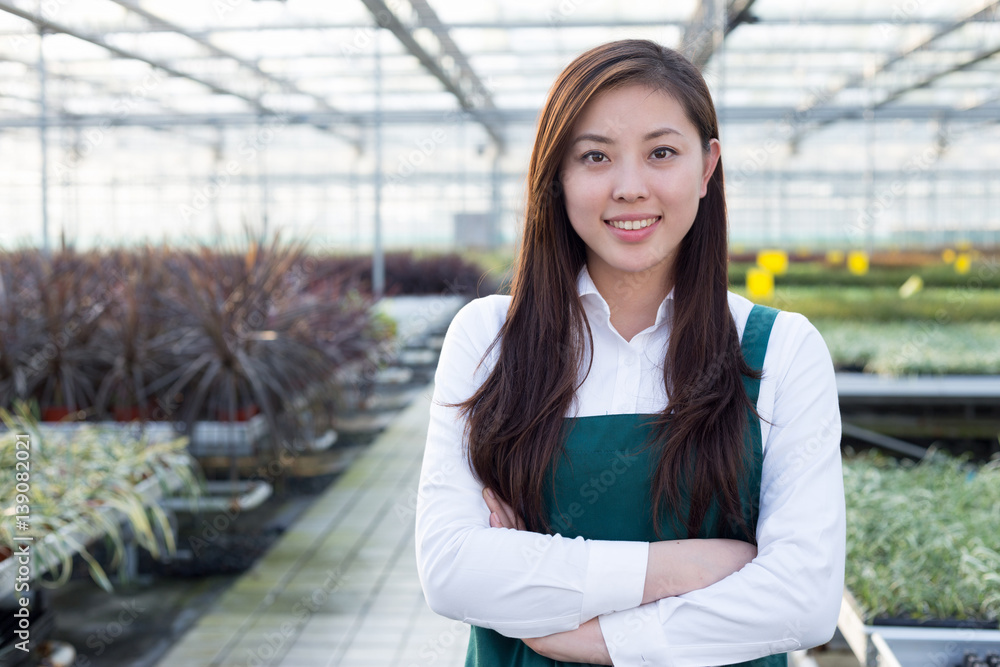 young asian woman works in green house