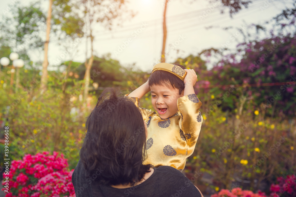 Happy kid having fun in traditional dress  Ao Dai with mom.