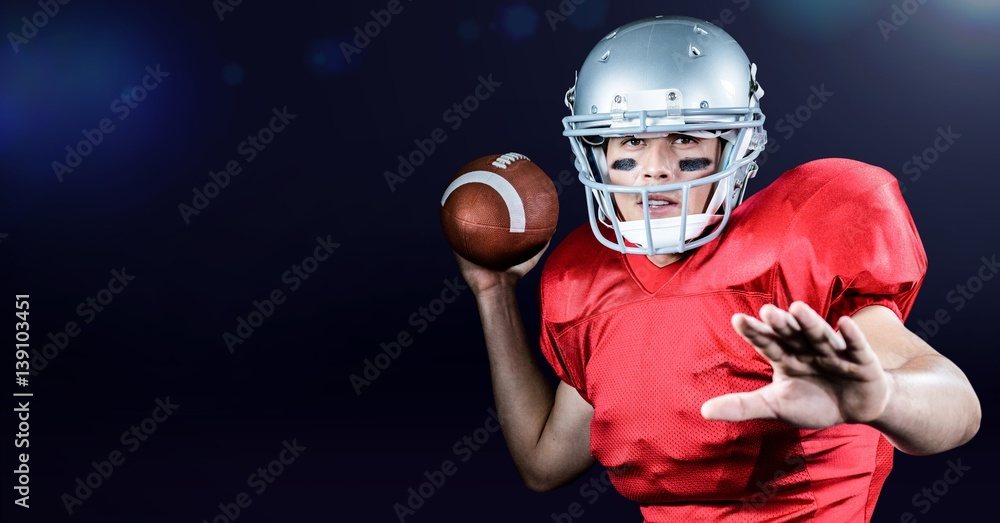 American football player throwing ball against blue background