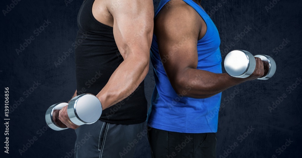 Mid section of healthy men working out with dumb bells