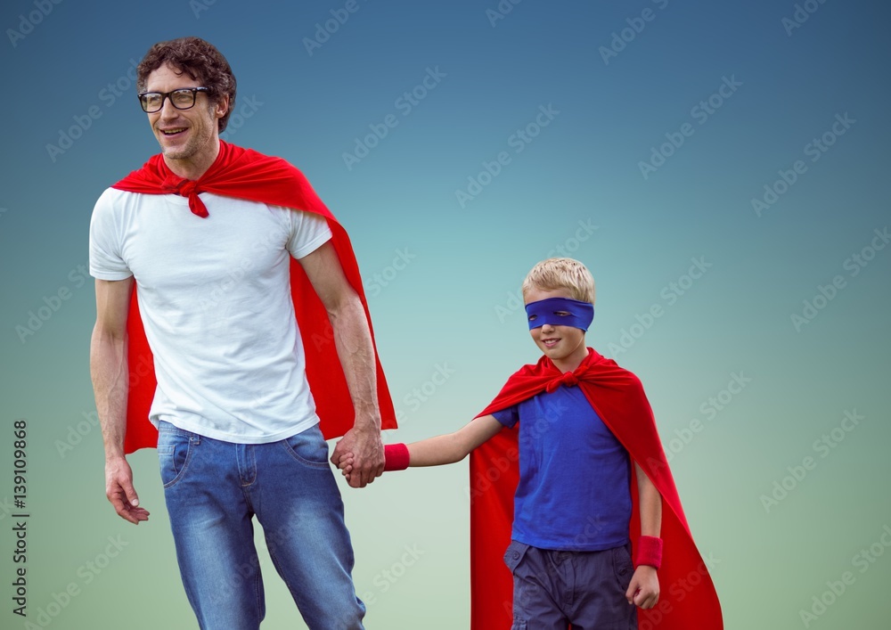 Father and son in superhero costume against blue background