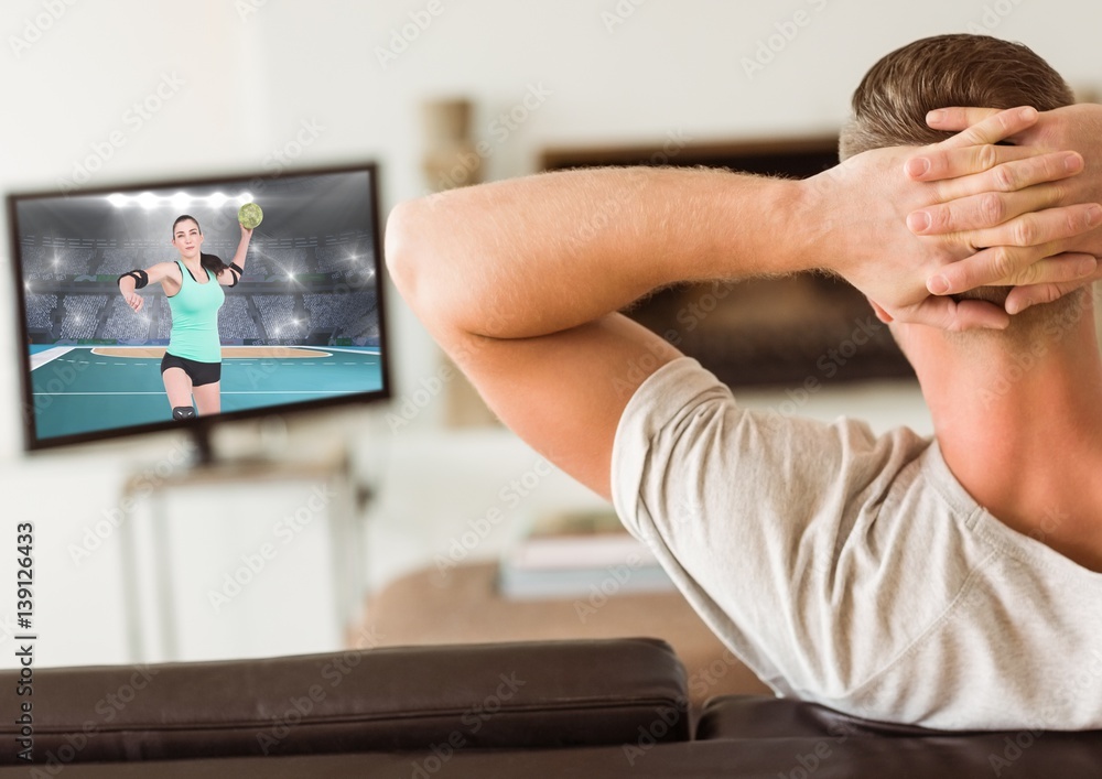 Man watching handball on television at home