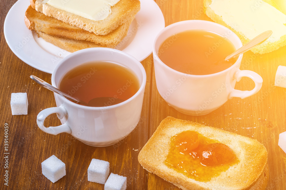 Romantic breakfast for two with cup of hot tea and cherry jam with toasted bread and butter