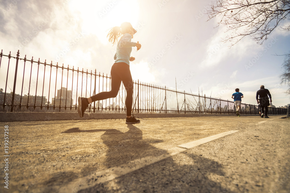 Young woman runner running on the road at morning