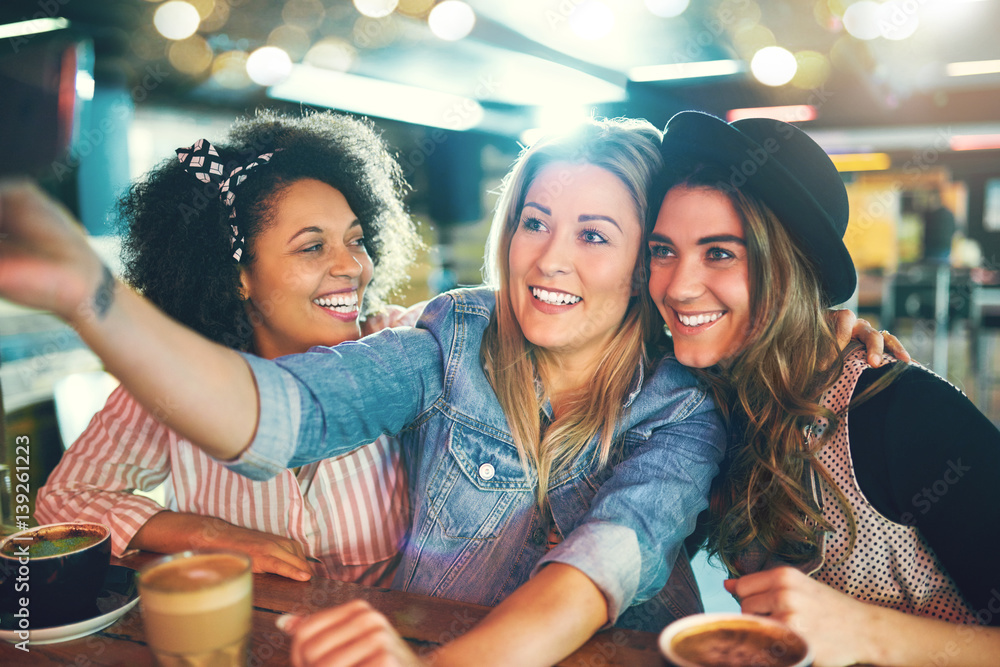 Three fun young women posing for a selfie