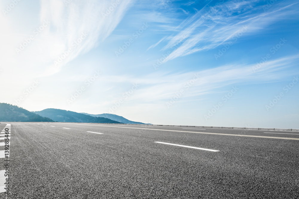 asphalt road and hill under the blue sky