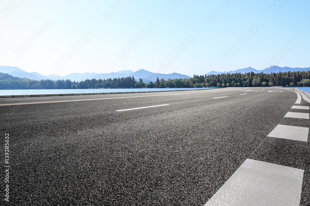 asphalt road and hills under the blue sky