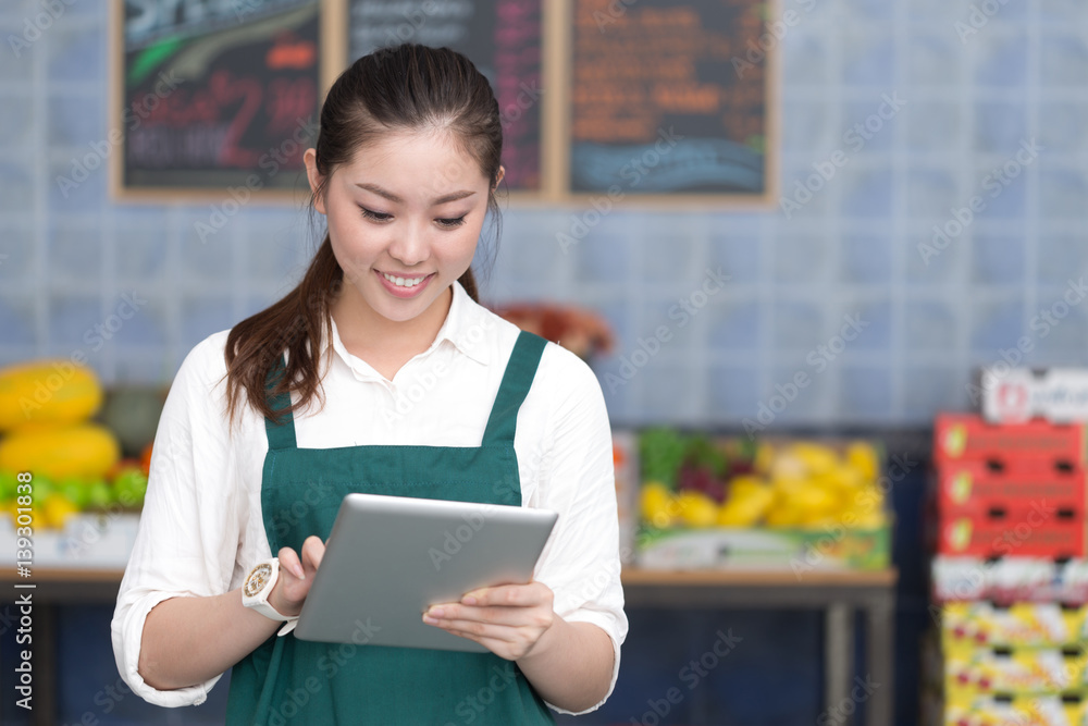 young pretty woman works in fruit store