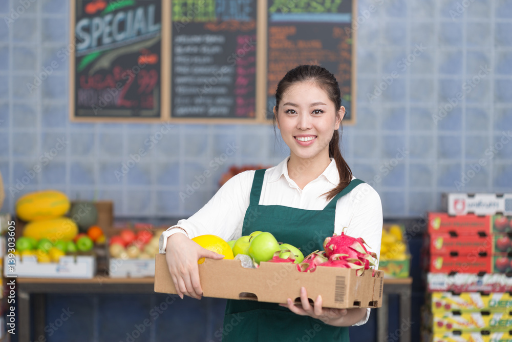 young pretty woman works in fruit store