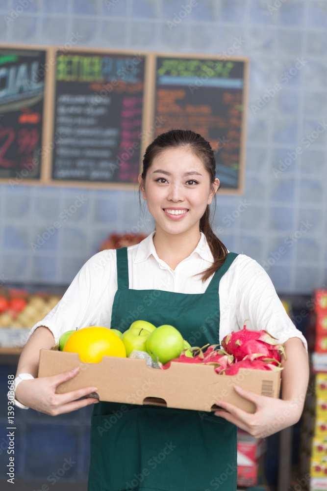 年轻漂亮女人在水果店工作