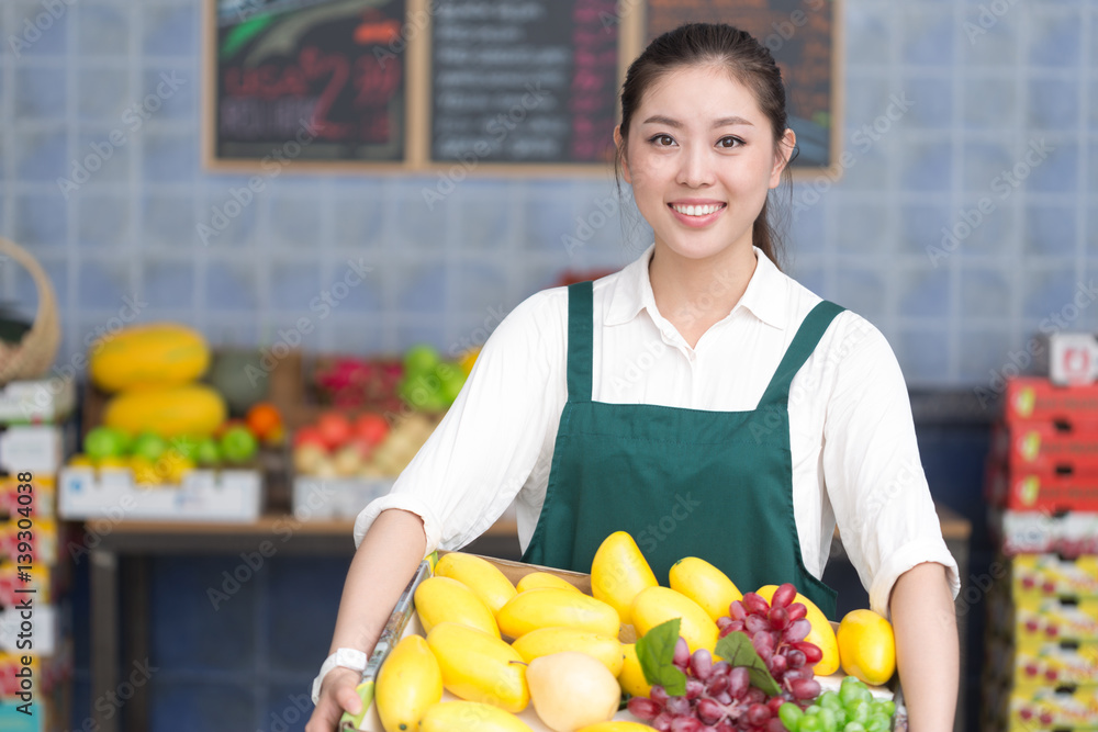 young pretty woman works in fruit store