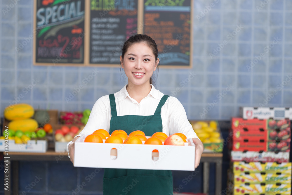 年轻漂亮女人在水果店工作