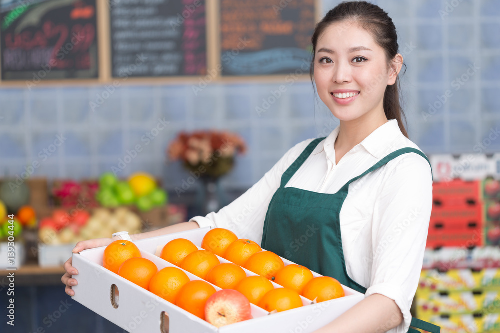 young pretty woman works in fruit store