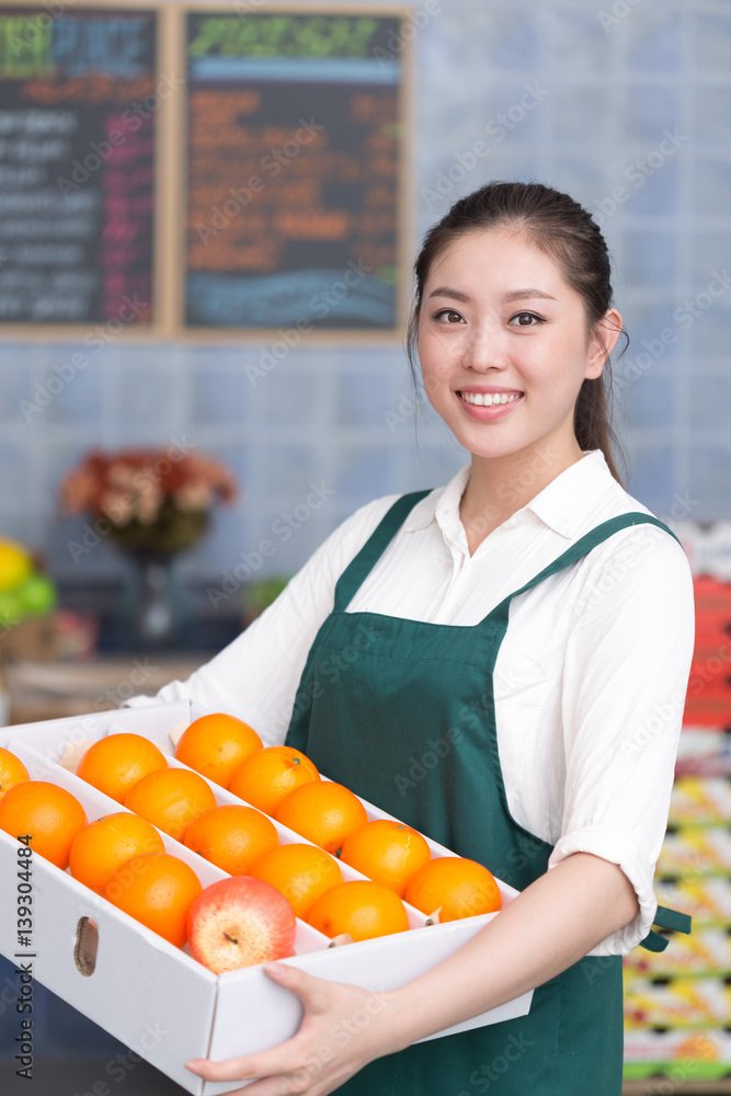 young pretty woman works in fruit store