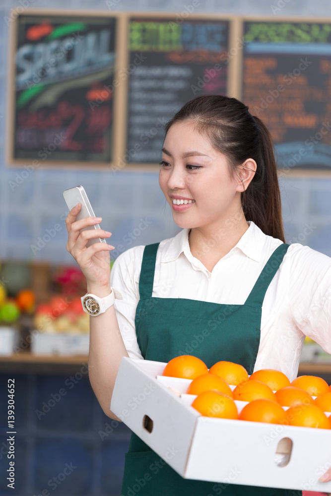 young pretty woman works in fruit store