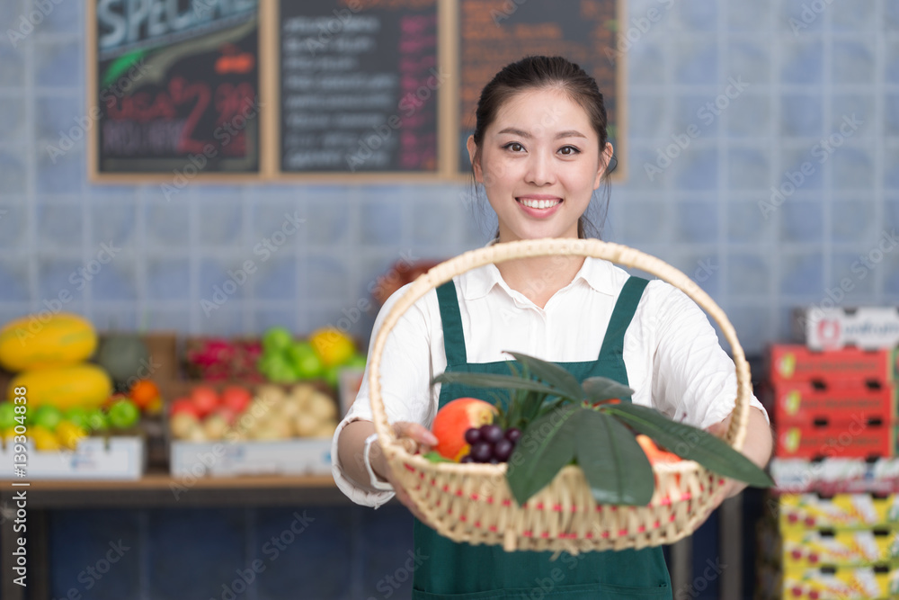 young pretty woman works in fruit store