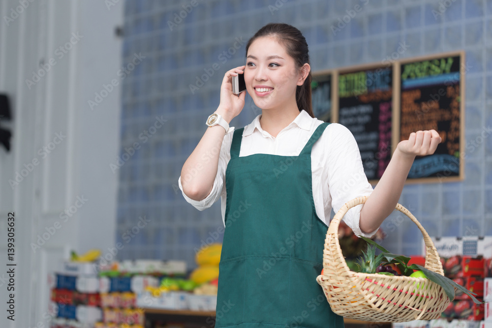 young pretty woman works in fruit store