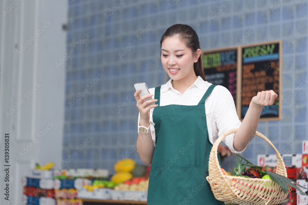 young pretty woman works in fruit store