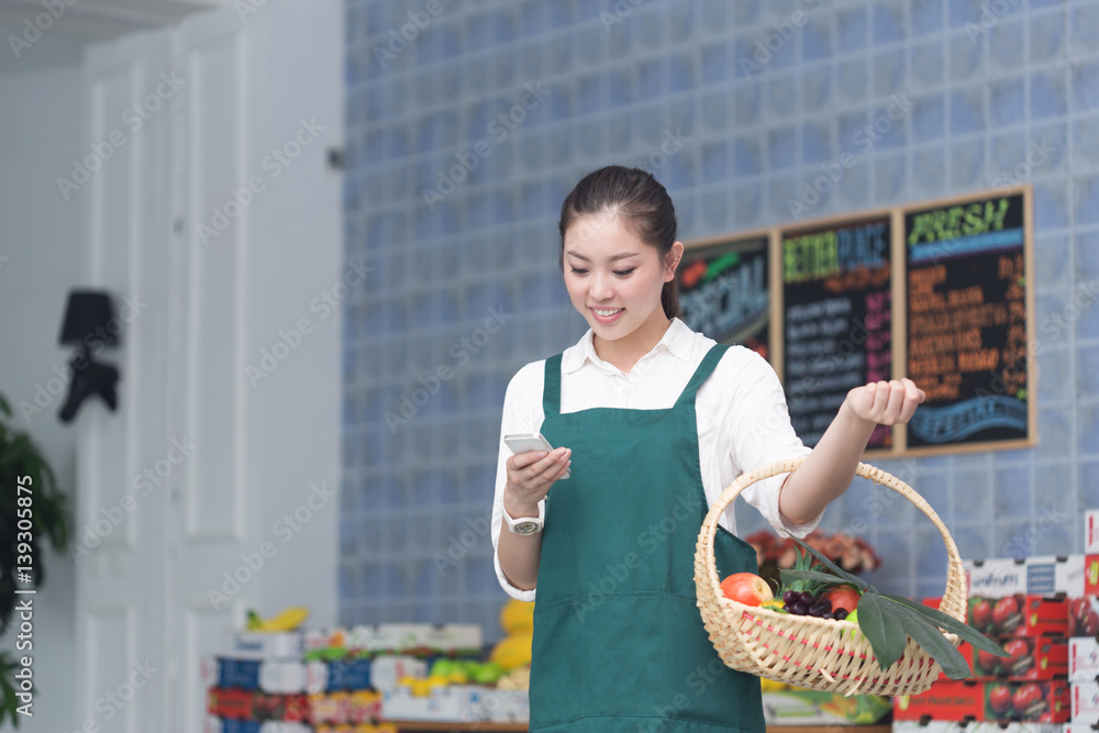 年轻漂亮女人在水果店工作