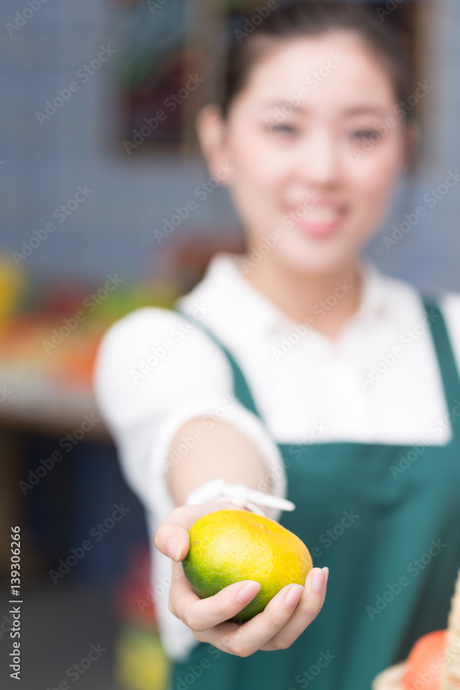 young pretty woman works in fruit store