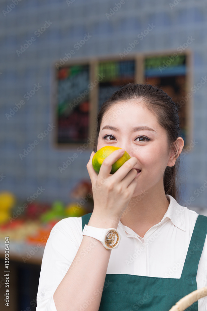 young pretty woman works in fruit store