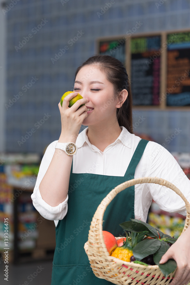 年轻漂亮女人在水果店工作