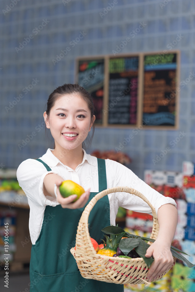 年轻漂亮女人在水果店工作