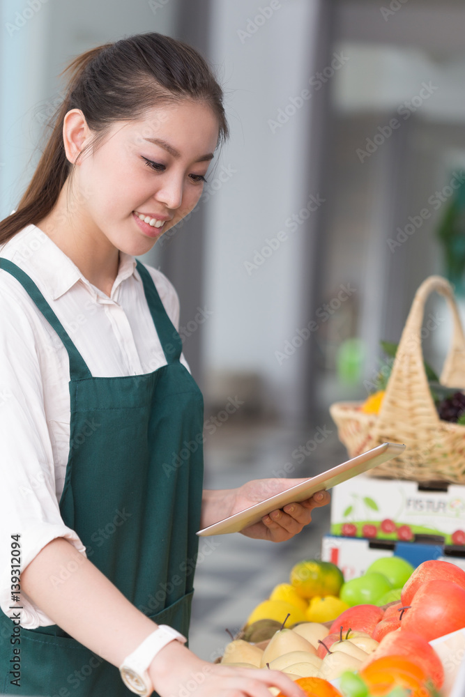 年轻漂亮女人在水果店工作