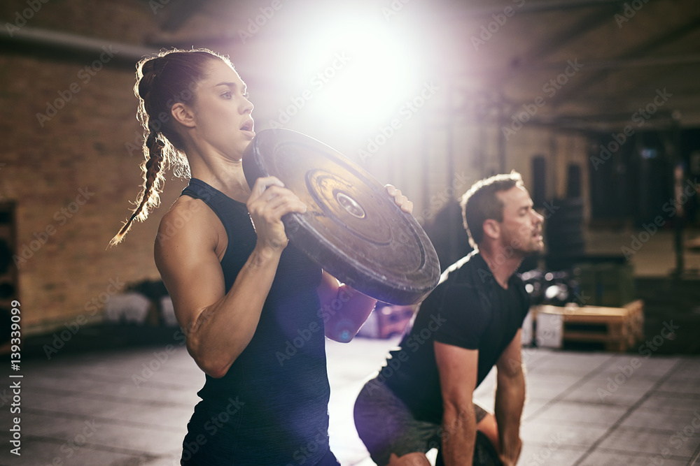 Two sportsmen having workout with weight disks