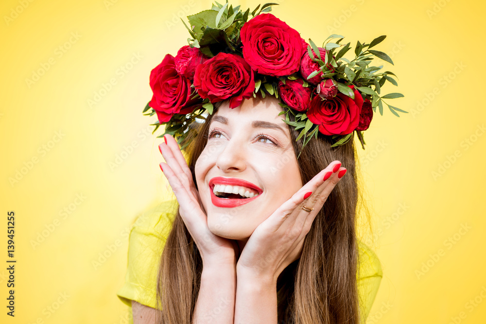 Close-up portrait of a beautiful woman with wreath made of red roses on the yellow background