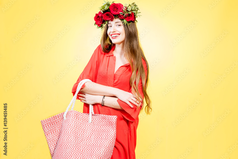 Colorful portrait of a beautiful woman in red dress with wreath made of red roses standing with shop