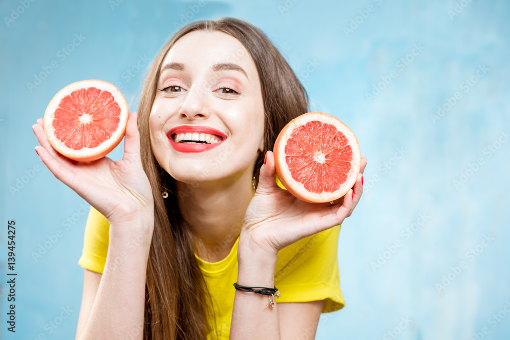 Colorful portrait of a beautiful woman grapefruit slices on the yellow background