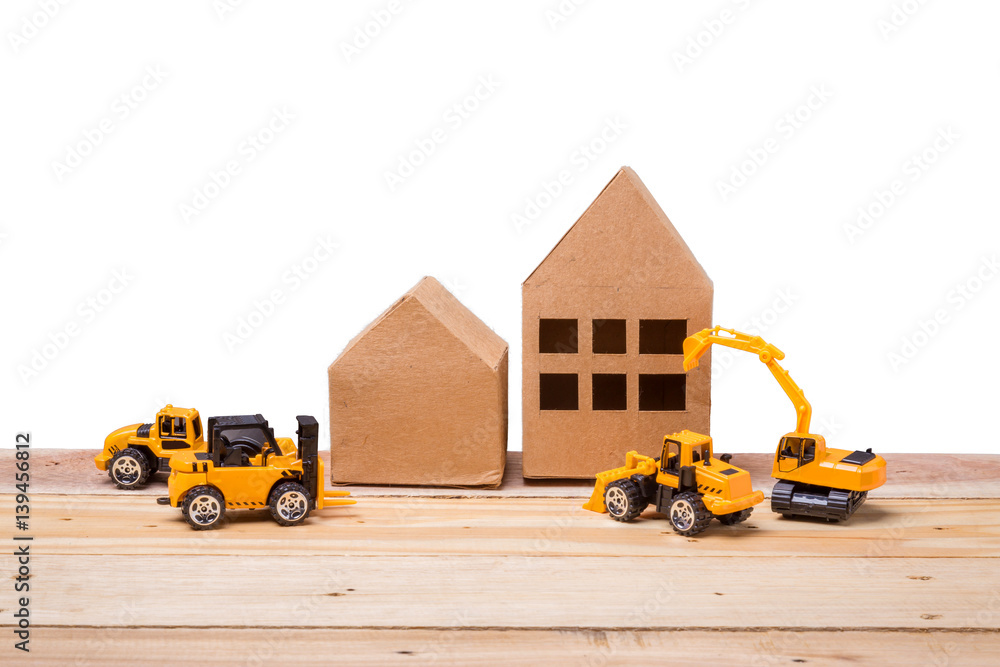 house paper model with toy car construction ideas concept on wooden floor and grey background