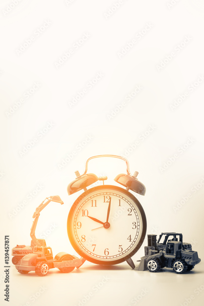 time concept with black alarmclock and consruction toy car with free copyspace for your text