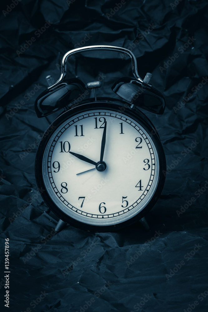 black alrm clock on trash crumpled red paper times concept