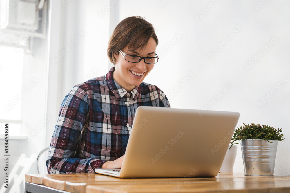 Pretty young girl sitting at desk and doing her homework